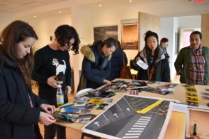 A group of people looking at photographs on a table